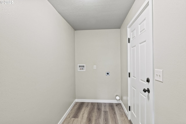 laundry room with hookup for a washing machine, a textured ceiling, light hardwood / wood-style flooring, and electric dryer hookup