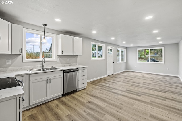 kitchen featuring white cabinetry, pendant lighting, stainless steel dishwasher, and sink