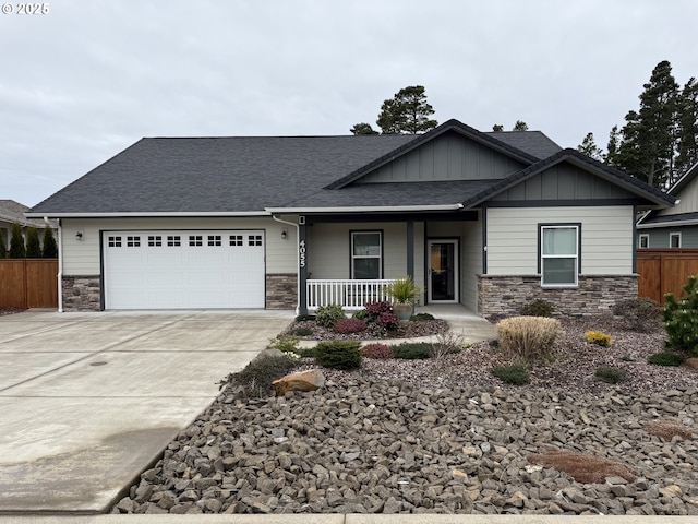 craftsman-style home with covered porch, stone siding, board and batten siding, and an attached garage