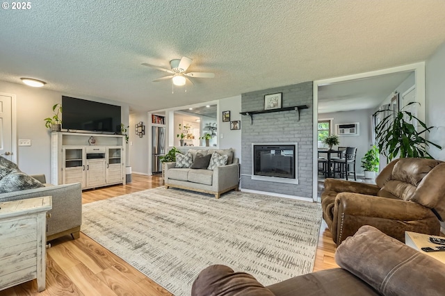 8413 NE Lewis Dr, Vancouver, WA 98662 - living area featuring wood finished floors, a ceiling fan, a brick fireplace, and a textured ceiling