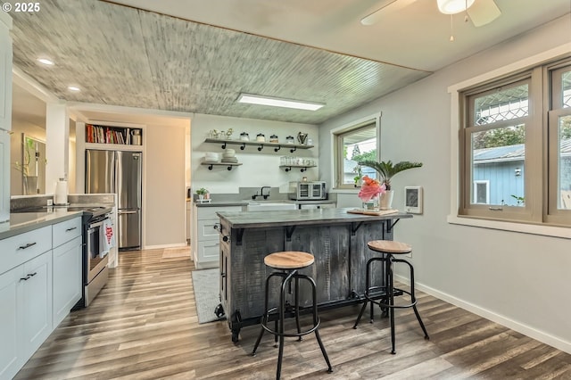8413 NE Lewis Dr, Vancouver, WA 98662 - kitchen featuring stainless steel appliances, a kitchen bar, wood finished floors, open shelves, and recessed lighting