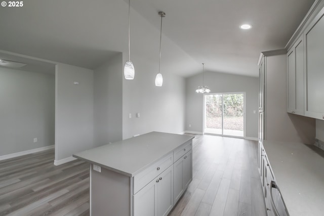 kitchen featuring lofted ceiling, light wood-style flooring, open floor plan, a center island, and pendant lighting