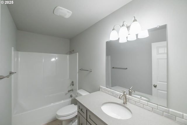 bathroom with washtub / shower combination, vanity, and toilet