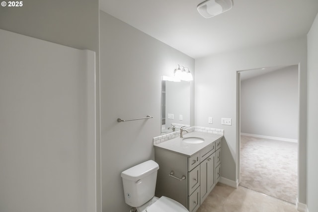 bathroom with vanity, toilet, and baseboards