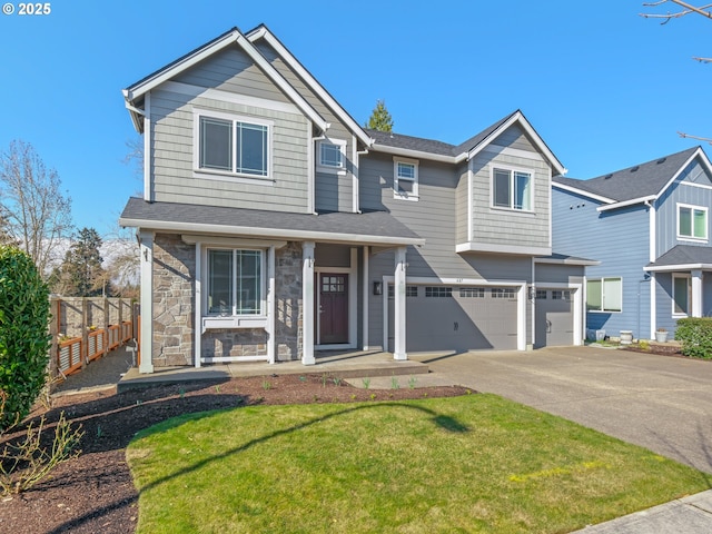 view of front facade with fence, a garage, stone siding, driveway, and a front lawn