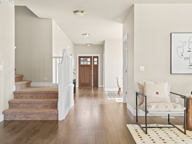 foyer with dark wood-style floors, stairs, and baseboards