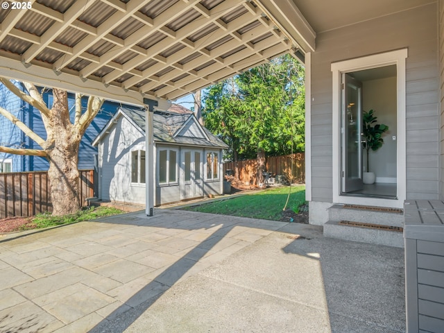 view of patio featuring an outbuilding and fence