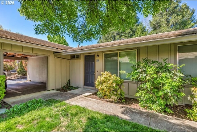 doorway to property featuring board and batten siding and driveway