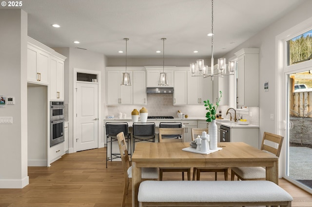 4420 NW 178th Ter Lot 27, Portland, OR 97229 - kitchen with light wood-style flooring, a chandelier, recessed lighting, decorative backsplash, and light countertops