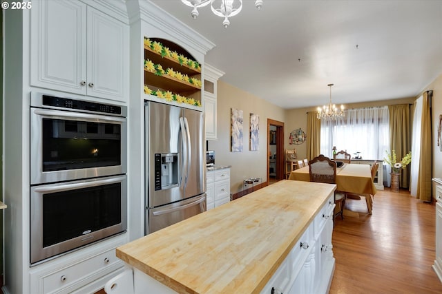 636 S Nehalem St, Clatskanie, OR 97016 - kitchen featuring a chandelier, stainless steel appliances, wood counters, open shelves, and white cabinetry