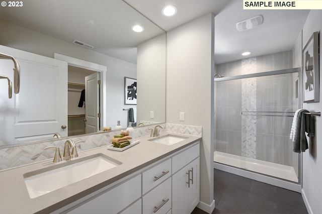 bathroom featuring vanity, tile patterned flooring, and a shower with shower door