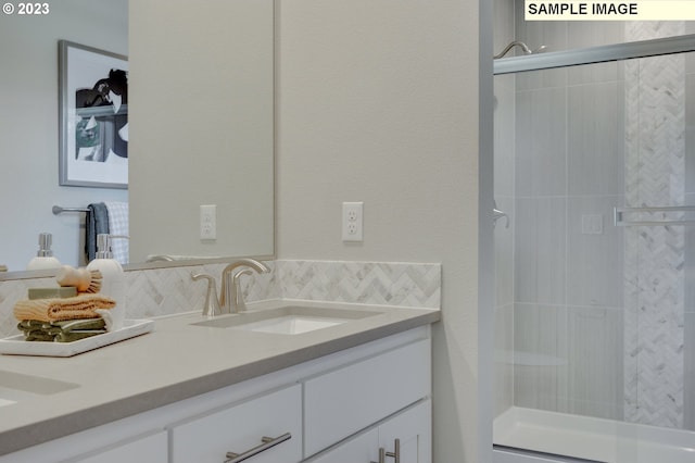 bathroom featuring vanity, decorative backsplash, and walk in shower