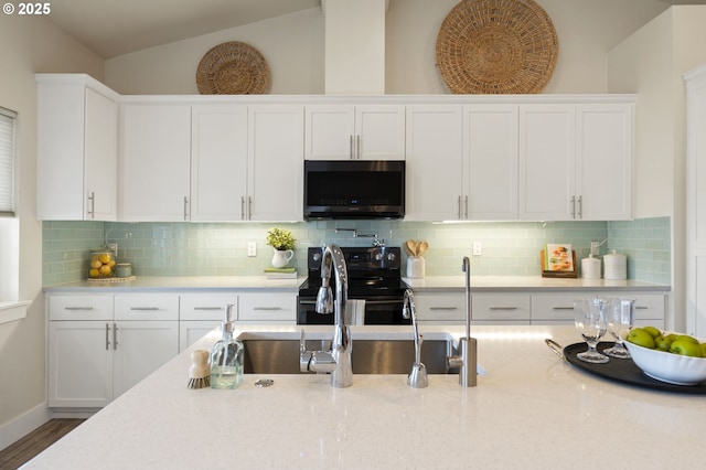 367 E 4th St, Lowell, OR 97452 - kitchen featuring stainless steel microwave, black range with electric cooktop, white cabinets, lofted ceiling, and tasteful backsplash
