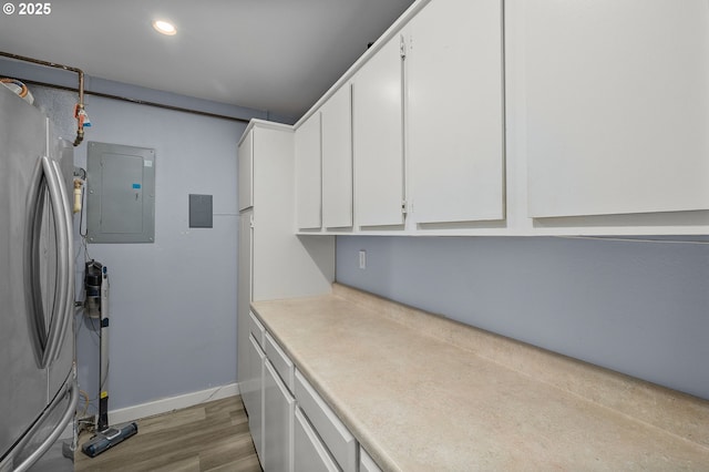 620 N Hayden Bay Dr, Portland, OR 97217 - kitchen featuring electric panel, freestanding refrigerator, white cabinetry, light wood-style floors, and recessed lighting