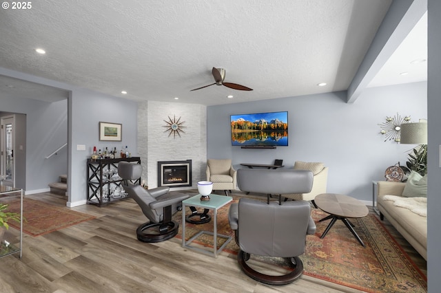 620 N Hayden Bay Dr, Portland, OR 97217 - living area with wood finished floors, a ceiling fan, a textured ceiling, stairs, and a fireplace