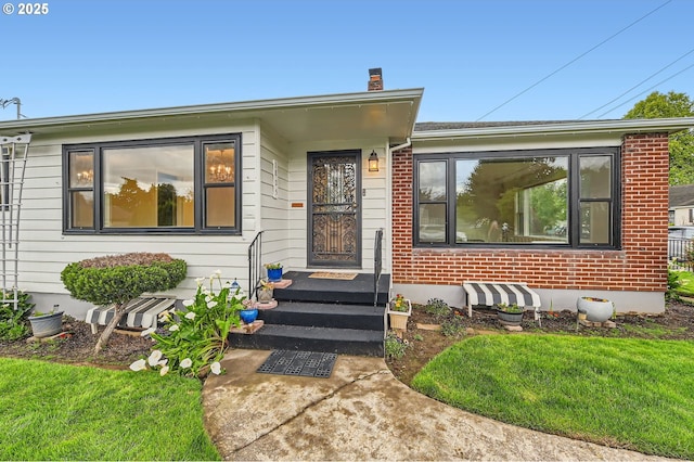 1805 NE Saratoga St, Portland, OR 97211 - view of front of home featuring a chimney, brick siding, and a front yard