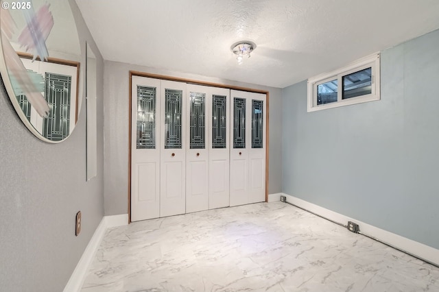 1805 NE Saratoga St, Portland, OR 97211 - unfurnished bedroom with light marble finish floors, baseboards, a textured ceiling, and a closet