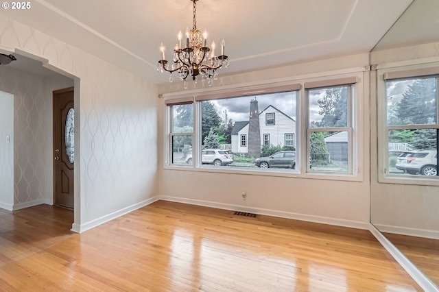 1805 NE Saratoga St, Portland, OR 97211 - unfurnished dining area with light wood-style flooring, a chandelier, baseboards, and a raised ceiling