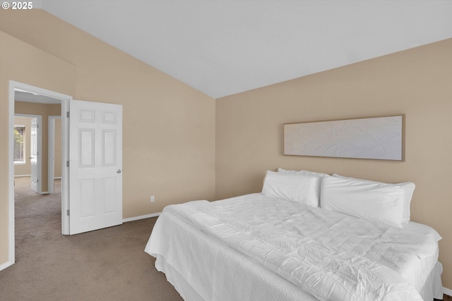 carpeted bedroom featuring baseboards and vaulted ceiling