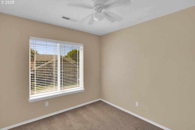 empty room featuring baseboards, ceiling fan, carpet floors, and a textured ceiling