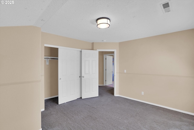 unfurnished bedroom with carpet floors, baseboards, a closet, and a textured ceiling
