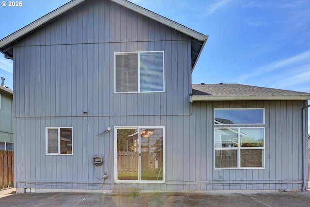 rear view of property with a shingled roof and a patio area
