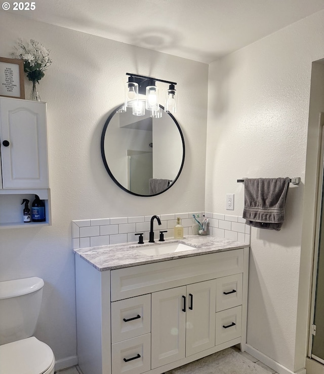 1689 NW Martin Ave, Roseburg, OR 97471 - bathroom featuring decorative backsplash, vanity, toilet, and baseboards