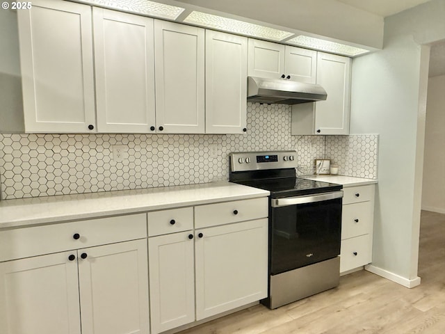 1689 NW Martin Ave, Roseburg, OR 97471 - kitchen featuring stainless steel electric range, under cabinet range hood, light countertops, tasteful backsplash, and light wood-type flooring