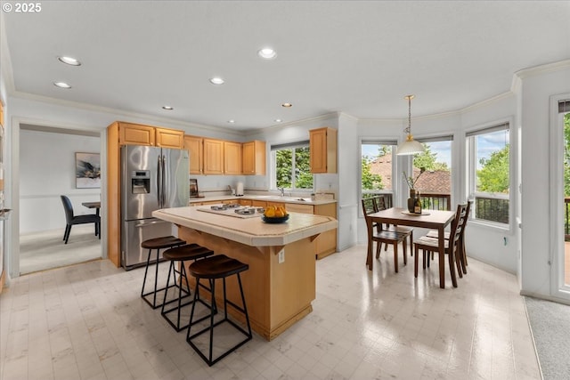 16605 SW Sumac St, Beaverton, OR 97007 - kitchen with stainless steel refrigerator with ice dispenser, ornamental molding, tile counters, a center island, and a breakfast bar