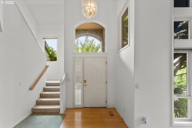 16605 SW Sumac St, Beaverton, OR 97007 - entryway featuring a chandelier, stairway, wood finished floors, and baseboards
