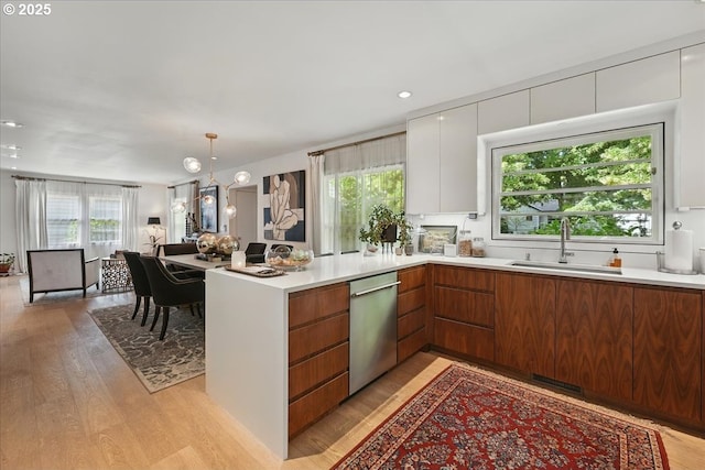 7338 N Chase Ave, Portland, OR 97217 - kitchen with stainless steel dishwasher, modern cabinets, light countertops, light wood-style floors, and recessed lighting