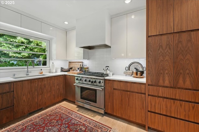 7338 N Chase Ave, Portland, OR 97217 - kitchen featuring stainless steel range, light countertops, backsplash, and modern cabinets