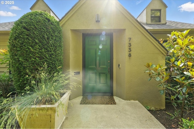7338 N Chase Ave, Portland, OR 97217 - view of exterior entry featuring stucco siding and roof with shingles