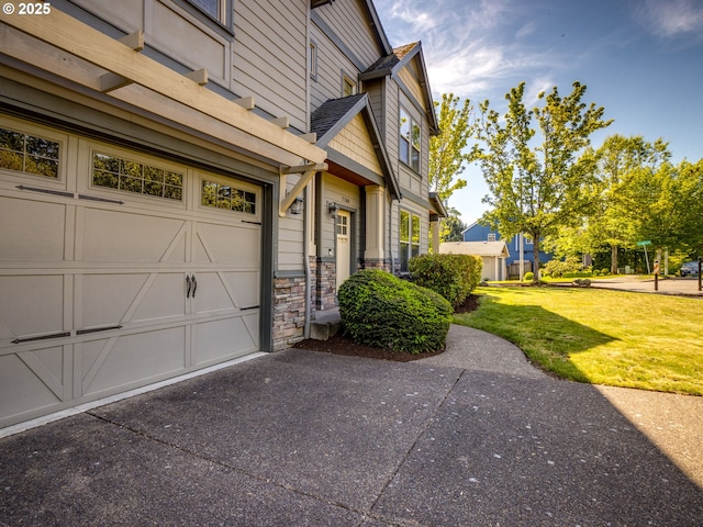 7760 SW Hyland Way, Beaverton, OR 97008 - view of home's exterior with stone siding, a yard, a garage, and asphalt driveway