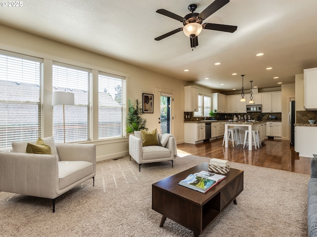 7760 SW Hyland Way, Beaverton, OR 97008 - living area featuring dark colored carpet, ceiling fan, recessed lighting, and baseboards