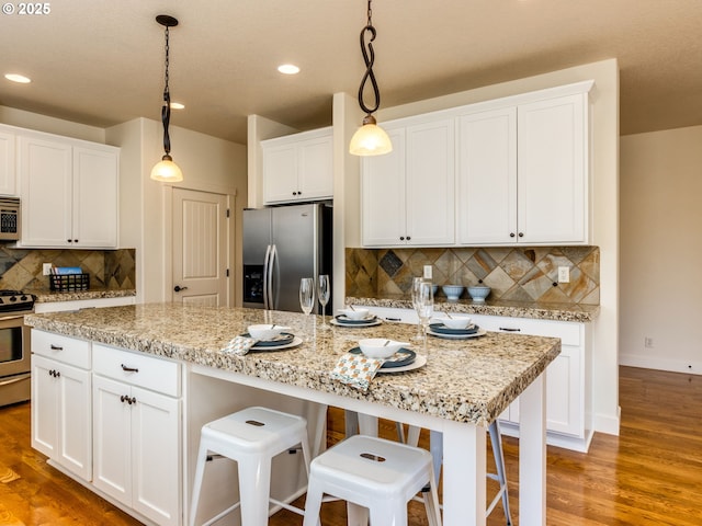 7760 SW Hyland Way, Beaverton, OR 97008 - kitchen featuring appliances with stainless steel finishes, white cabinets, tasteful backsplash, recessed lighting, and hanging light fixtures