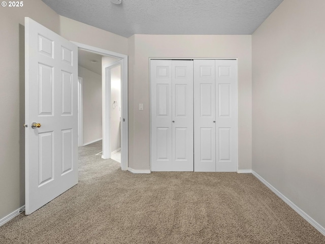 unfurnished bedroom featuring carpet, a closet, and a textured ceiling