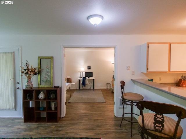 interior space with baseboards and dark wood-style flooring