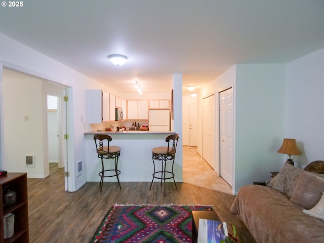 living room featuring visible vents and wood finished floors