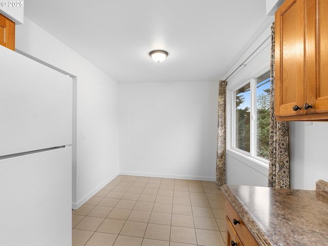 unfurnished dining area with light tile patterned flooring