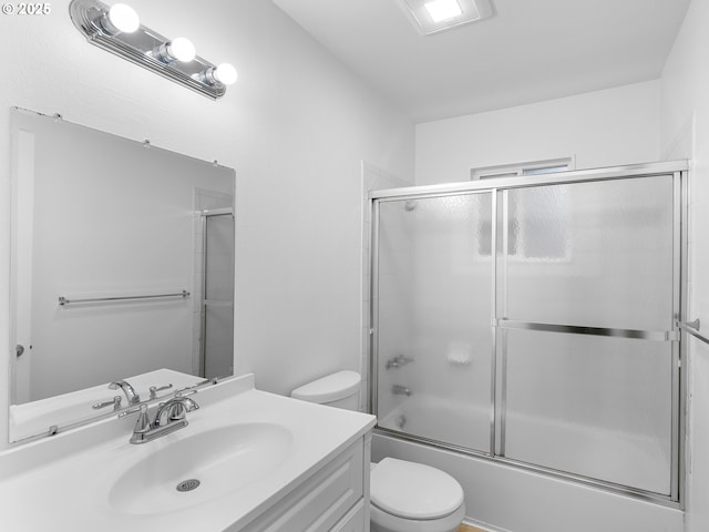 full bathroom featuring bath / shower combo with glass door, vanity, and toilet