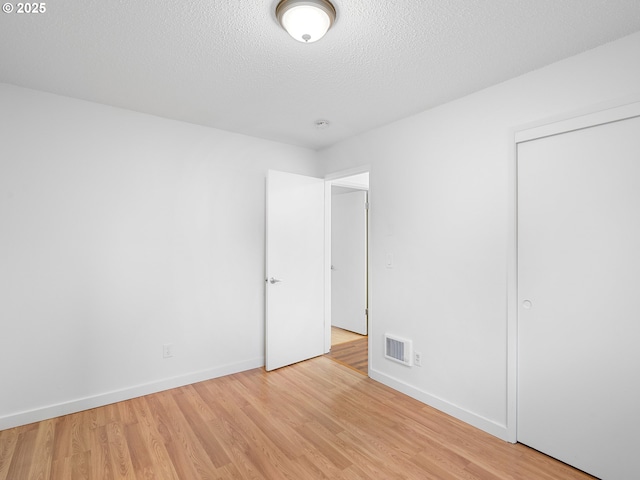 unfurnished bedroom featuring a textured ceiling and light wood-type flooring