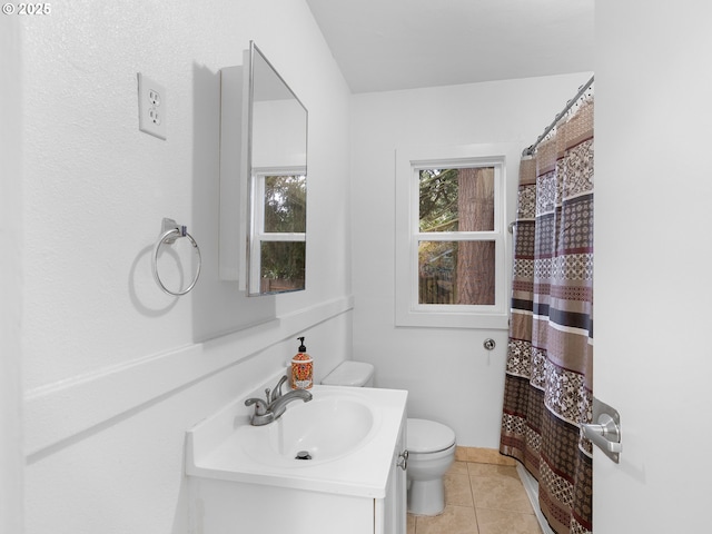 bathroom featuring toilet, tile patterned floors, walk in shower, and vanity