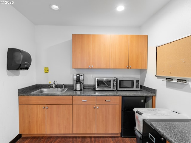 kitchen featuring sink, fridge, and dark hardwood / wood-style floors