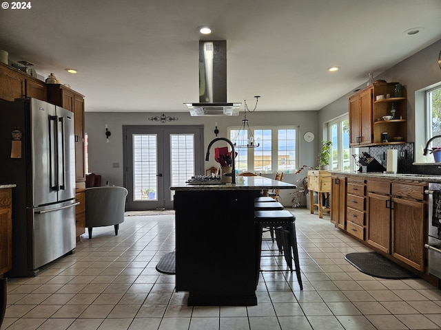 kitchen with french doors, ventilation hood, light tile patterned flooring, and freestanding refrigerator