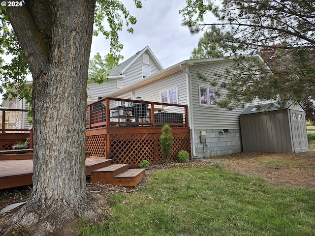 rear view of house with a storage shed, a deck, a lawn, and an outbuilding