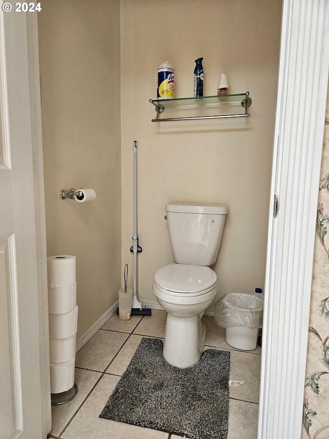 bathroom with toilet, tile patterned flooring, and baseboards