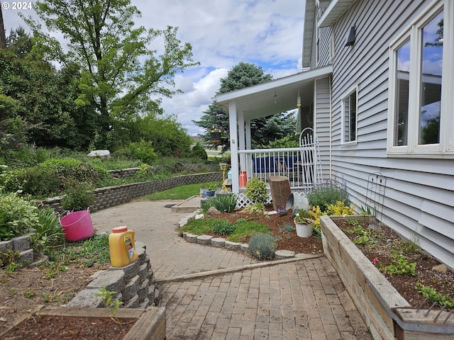 view of yard with covered porch and a vegetable garden