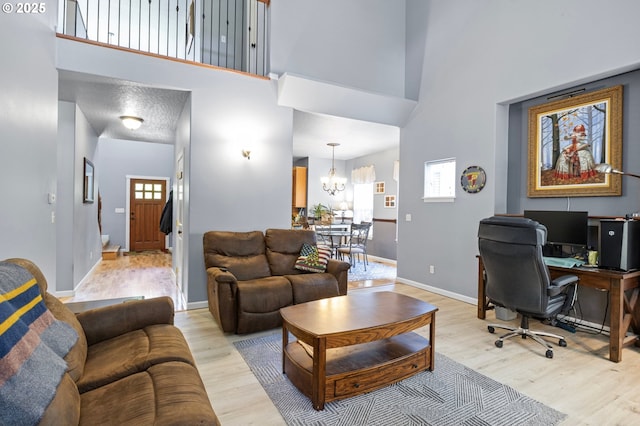 952 S 69th St, Springfield, OR 97478 - living room featuring light wood-type flooring, a chandelier, an office area, and a high ceiling