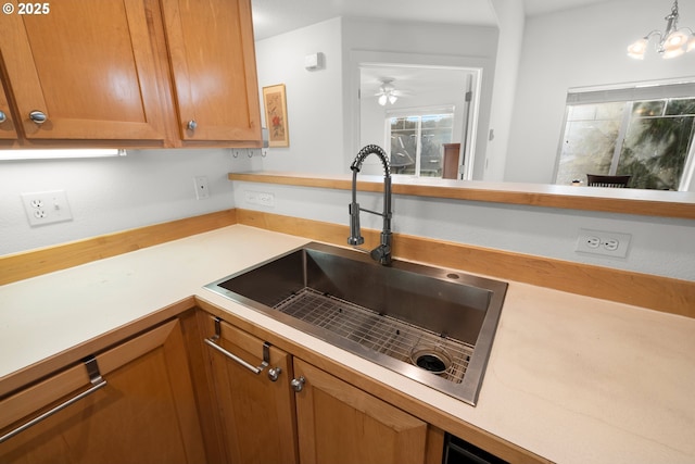 kitchen featuring pendant lighting, ceiling fan with notable chandelier, and sink